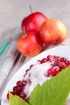 Plate of a cowberry sprinkled with sugar removed close up against a linen napkin