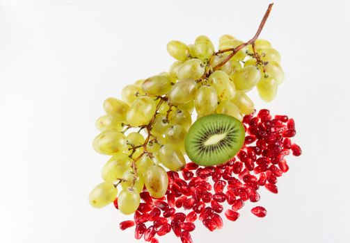 Grapes, grains of a pomegranate and kiwi removed on a white background without isolation