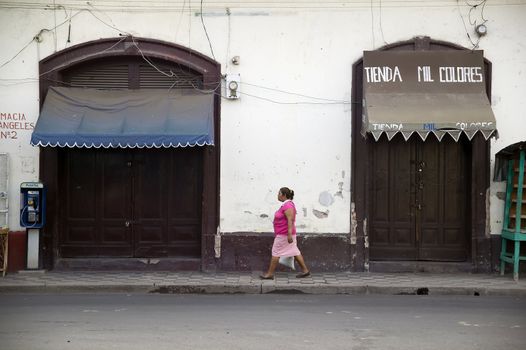 Woman walkson an urban street in Granada Nicaragua
