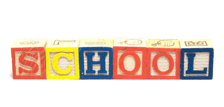 Wooden baby blocks spell the word school, isolated against a white background