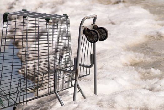 An abandoned shopping cart stuck in the ice