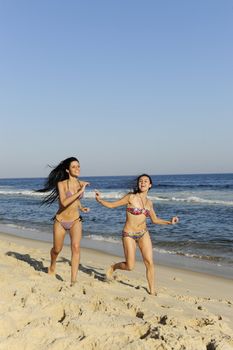 holiday fun: two girls having a racing duel on the beach