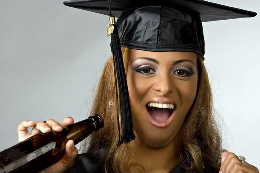 A young woman celebrating her graduation with a bottle of beer.