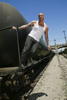 Male fashion model posing on a train