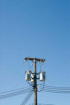 Powerline transformers shot against a blue sky, with additional room for text