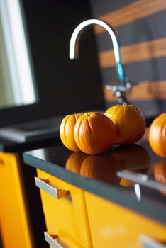 Orange in kitchen on table with reflections