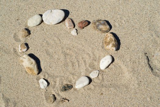 A heart shape on the beach, made of smooth stones