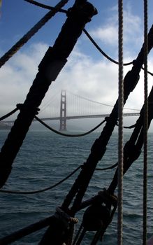 Golden Gate Bridge viewed through a sailing ships rigging when leaving the bay.