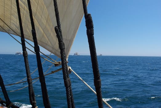 Three of the Farallon Islands viewed through the rigging of a sailing ship.