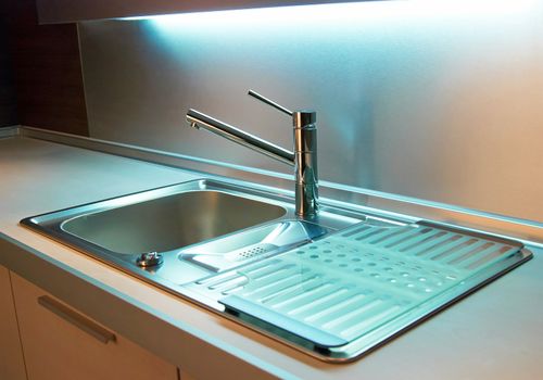 Modern stainless steel tap in white kitchen