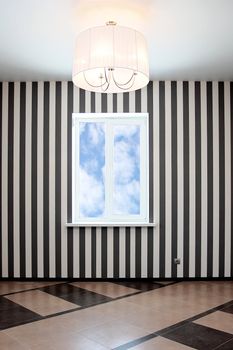 Empty room with a window and striped wall-paper
