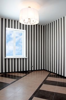 Empty room with a window and striped wall-paper
