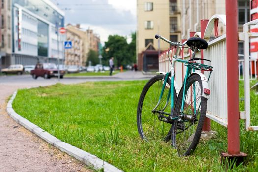 old-fashioned russian bike stand close to metal fence