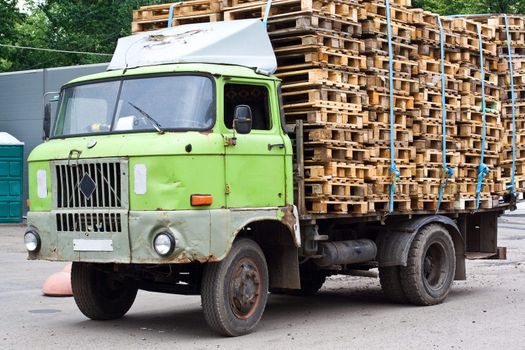 Old-fashioned rusty lorry with pallets