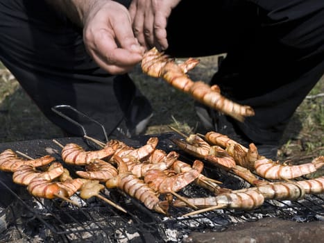 The man prepares shrimps on a grill. bbq