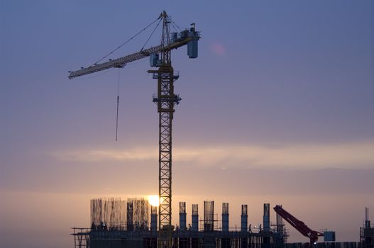 Tower crane on a construction site at sunrise