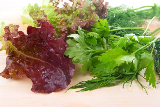 Salad,dill and parsley on wooden board