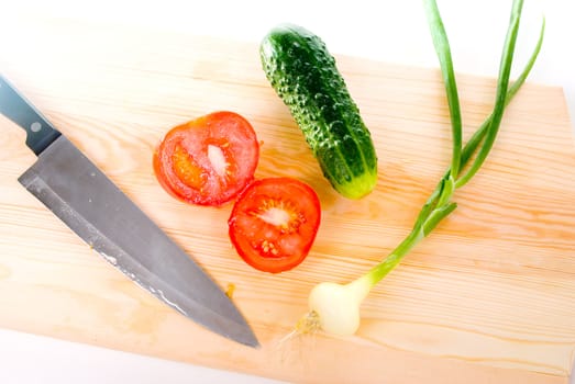 The Knife and fresh vegetables.Tomato,cucumber and onion