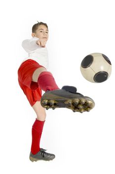 a boy in football uniform kicking a football