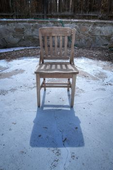 Broken desk chair sitting in a swimming pool in winter.