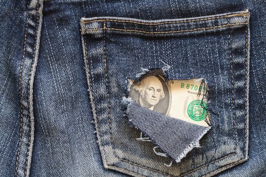 One dollar note inside hole in old jeans pocket