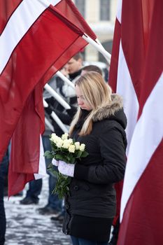 RIGA, LATVIA, MARCH 16, 2010: Young girl at Commemoration of the Latvian Waffen SS unit or Legionnaires.The event is always drawing crowds of nationalist supporters and anti-fascist demonstrators. Many Latvians were forcibly called to join the Latvian SS Legion.
