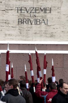 RIGA, LATVIA, MARCH 16, 2010: Latvian flags at Freedom monument. Commemoration of the Latvian Waffen SS unit or Legionnaires.The event is always drawing crowds of nationalist supporters and anti-fascist demonstrators. Many Latvians were forcibly called to join the Latvian SS Legion.