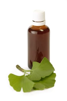 Medicine flask and gingko leaves - isolated on white background