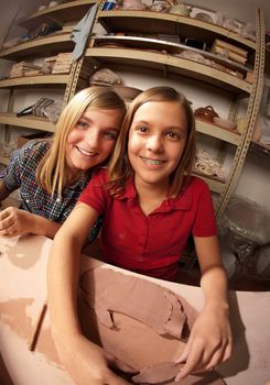 Cute young girls working on projects in a clay studio