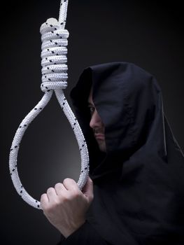 A headsman is looking askance to the camera while holding a noose.