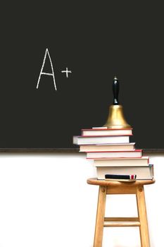 School books on stool with chalkboard