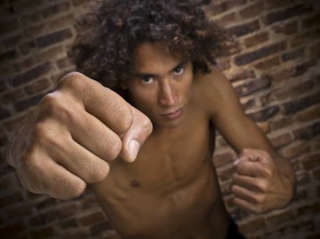 A young man throwing his fist to the camera. Focus on the hand.