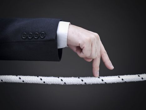 Close up of a businessman's fingers walking on the tightrope. Conceptual image. 