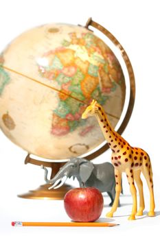 Globe with toys animals on white background