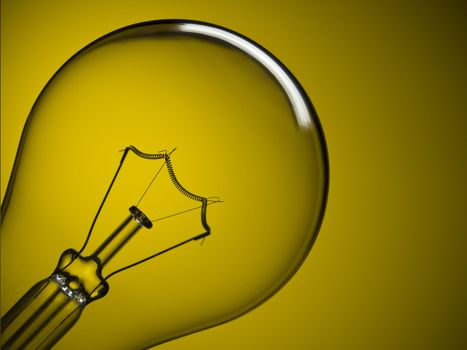 Close up on a transparent light bulb over a yellow background.