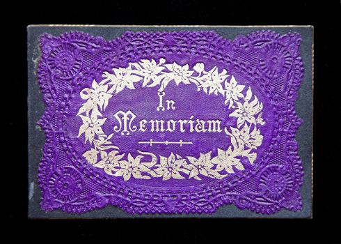 An antique embossed In Memorium card in purple and gold.