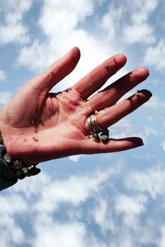 a hand full of earth against a beautiful blue sky