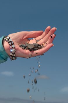 a hand full of earth against a beautiful blue sky