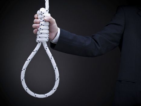 A man on a suit holds a hangman's noose over a gray background.