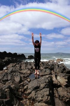 a beautiful woman chasing a rainbow to show a healthy way to live a happy and relaxed lifestyle in a world full of stress and that you should chase after your dreams