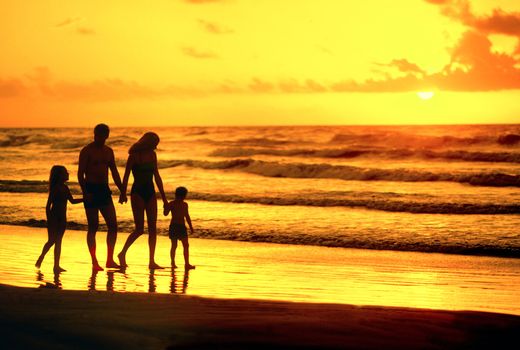 family walking on beach silhouette