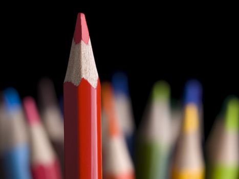 Sharp red pencil highlights over many other colored pencils.