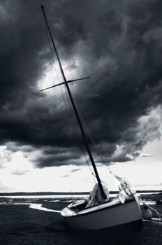 Gloomy black and white vertical shot of boat in low tide St John New Brunswick Canada