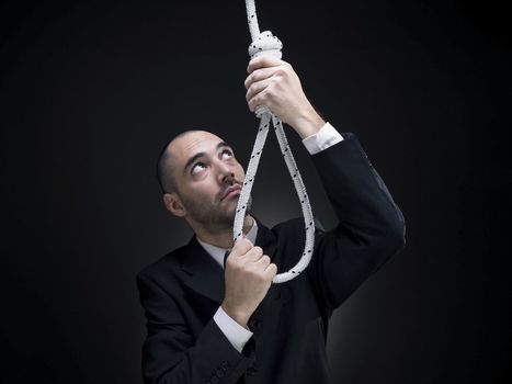 A businessman is setting up a noose.