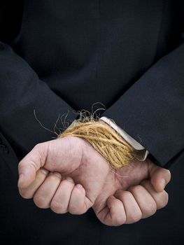 Closeup on a businessman's tied up hands.