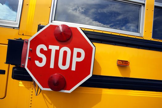 Side view of a school bus and its stop signal.
