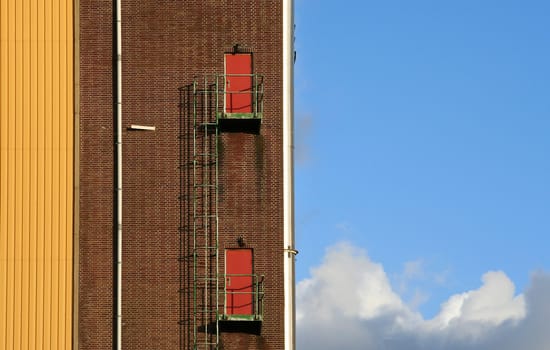 Detail of a factory, with a ladder and doors along the wall