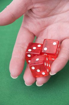  close up of a hand throwing dices on a green table