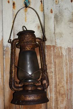 old petrol lamp hanging on a wooden wall