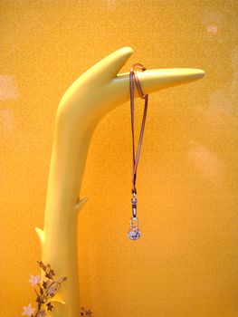 a window display with a necklace hanging on a model hand